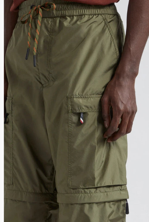 Close-up of a person wearing olive green cargo pants, showing the side pocket and waistband.