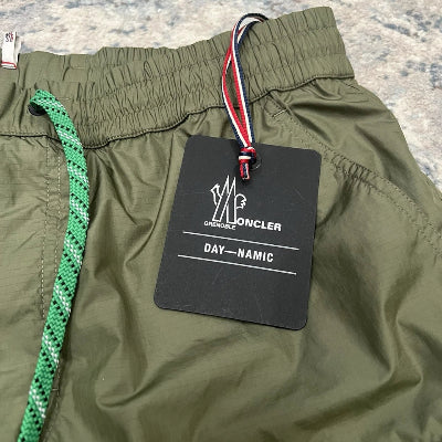 Green pants with a brand label on a plain background