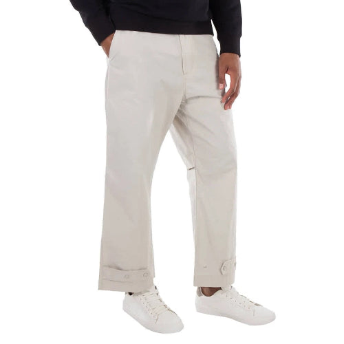 Person wearing beige pants and white sneakers on a white background