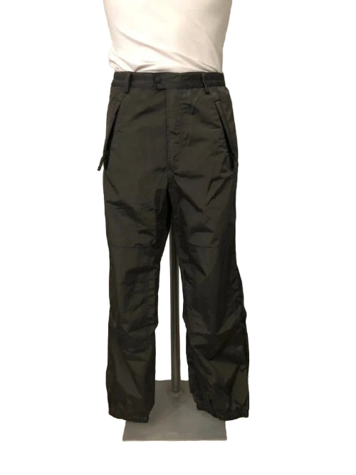 Black pants on a wooden floor with a white wall background