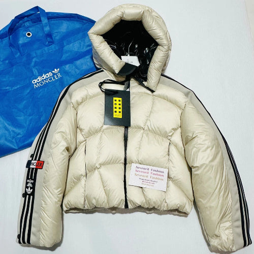 Beige puffer jacket with Adidas and Moncler branding on a white background