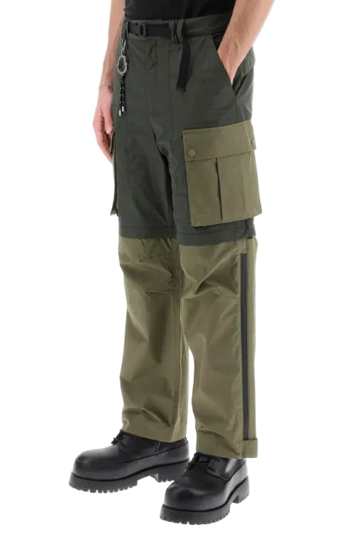 Olive green cargo pants with multiple utility pockets, worn by a model with black boots on a white background.