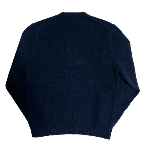 Navy blue sweater on a textured white background