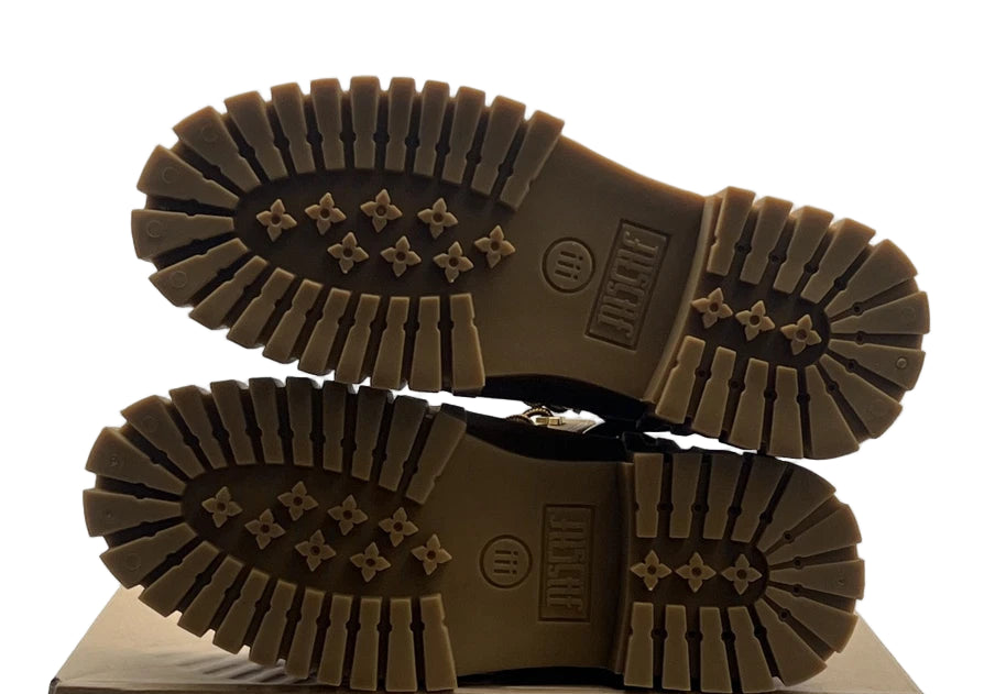 Brown boots with tread pattern on a cardboard box against a white background