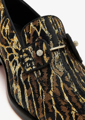 A close-up of a leopard print loafer featuring a brown and black animal pattern with a silver-tone metal eyelet and decorative strap.