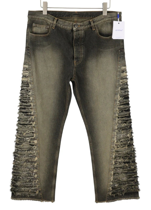 Distressed green jeans with frayed edges on a white background