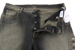 Close-up of a pair of dark green jeans with a tag on a white background