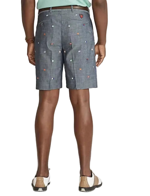 Person wearing blue shorts with colorful heart patterns on a plain background