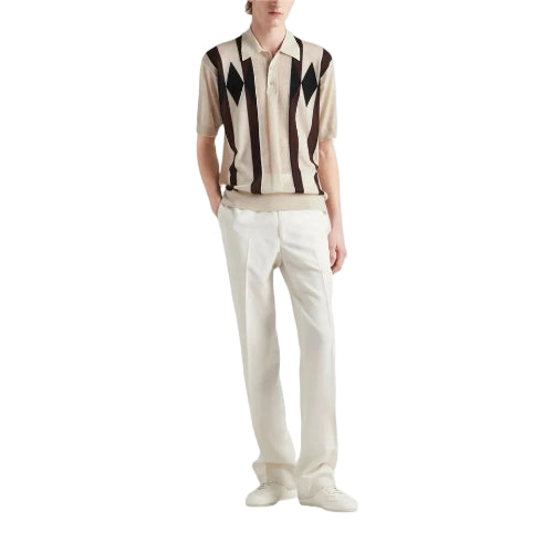 Person wearing a patterned shirt and white pants on a light gray background