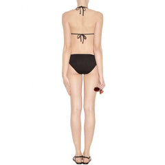 A model shown from the back wearing a black string bikini with a halter-style top and high-cut bottoms, paired with black strappy heels against a plain white background.