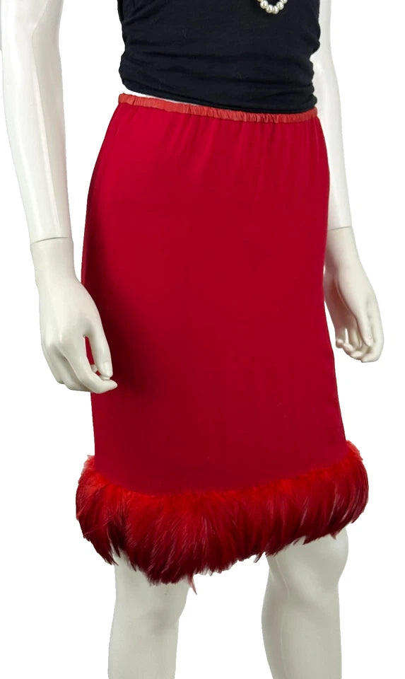 A bright red knit skirt with a fluffy feather-trimmed hem, displayed on a mannequin torso against a plain white background.