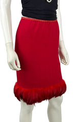 A bright red knit skirt with a fluffy feather-trimmed hem, displayed on a mannequin torso against a plain white background.