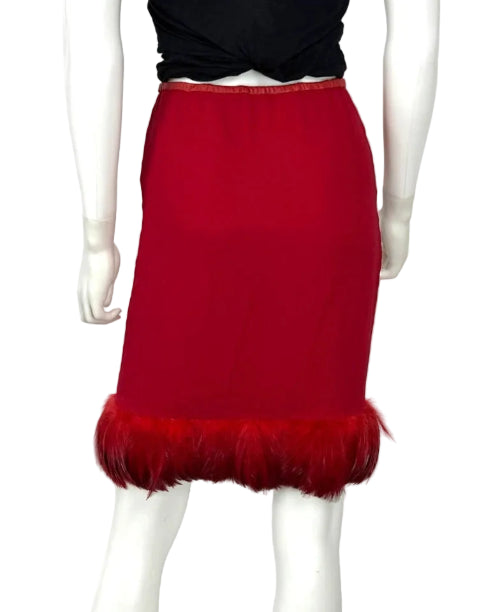 A red pencil skirt with a feathered hem, displayed on a white mannequin against a light gray background.