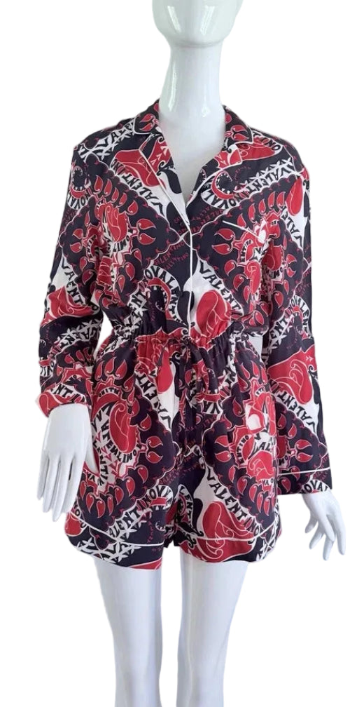 Mannequin wearing a patterned shirt with red, black, and white design on a plain background