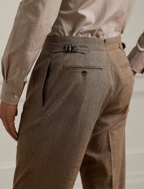 Close-up of a person wearing khaki trousers, showing the back pocket and waistband with belt loops.