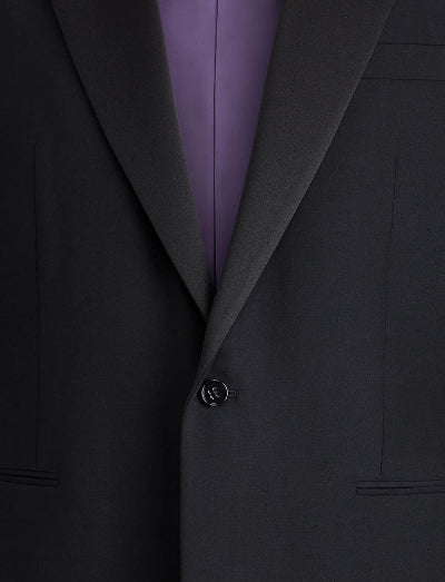 Close-up of a dark charcoal gray suit jacket with a single-button closure, worn over a purple dress shirt.