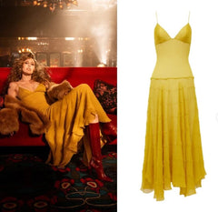 A yellow sleeveless midi dress with thin straps and a tiered skirt, shown in a lifestyle photo on the left worn by a model sitting on a red couch, and as a standalone product image on the right against a white background. The text 'STYLISHCYRUS' is visible at the bottom right.
