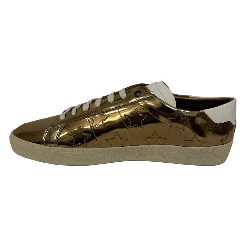 Gold metallic sneaker with white sole on a black background