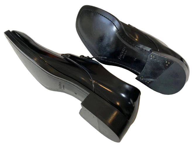 Pair of black dress shoes on a light gray surface