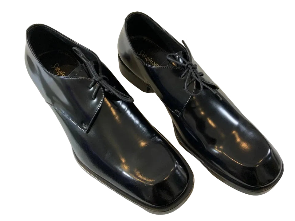 Pair of black dress shoes on a light-colored floor.