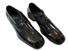 Pair of black dress shoes on a light-colored floor.
