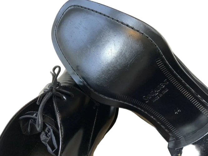 Close-up of a shiny black shoe with a reflective surface