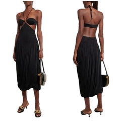 Black halter dress worn by a model on a white background