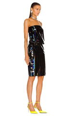 Woman wearing a black strapless dress with reflective material on a white background