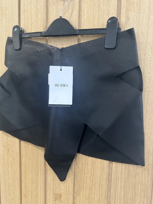 Black garment on a hanger with a visible tag on a wooden surface