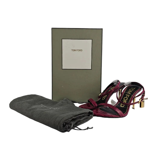 Folded gray blanket with a patterned scarf on top, next to a green box with a brand logo.