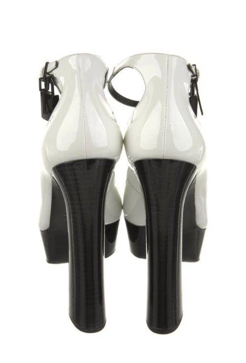 White high-heeled shoes with black soles on a white background