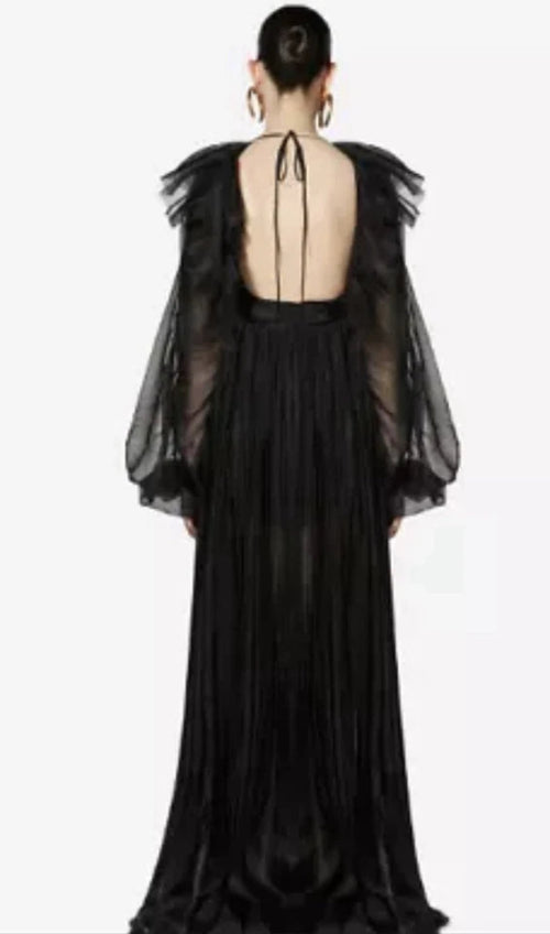 Black evening gown with sheer overlay and fur trim on a plain background