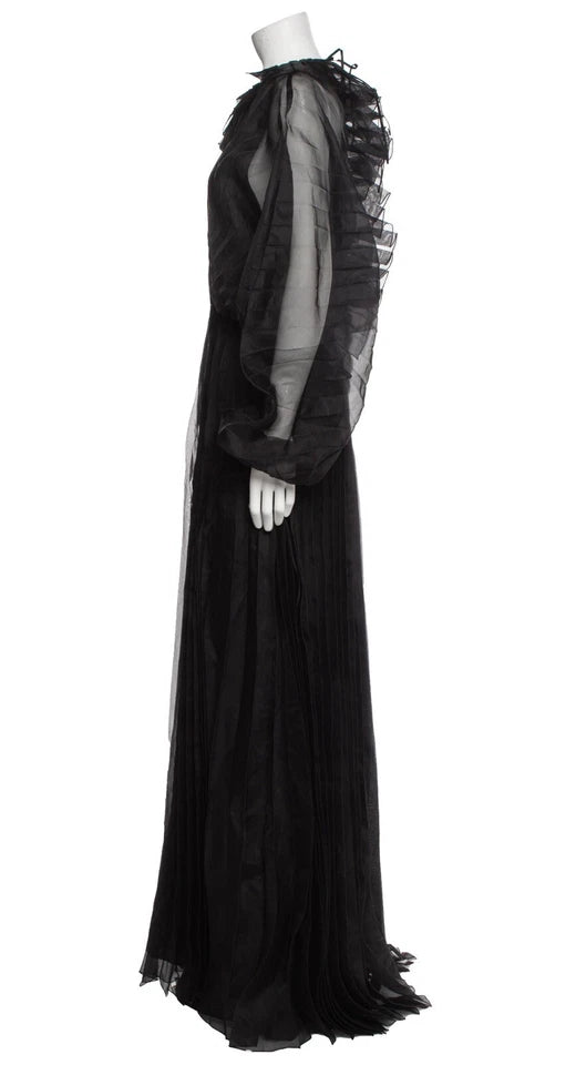 Black evening gown with sheer sleeves on a mannequin against a white background
