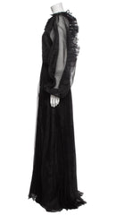 Black evening gown with sheer sleeves on a mannequin against a white background