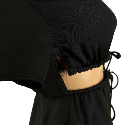 Black dress with a fitted bodice and flowing skirt on a plain background