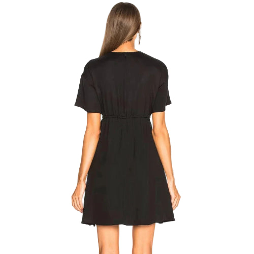 Woman wearing a black dress against a plain background