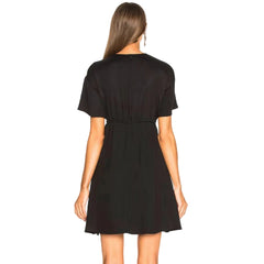 Woman wearing a black dress against a plain background