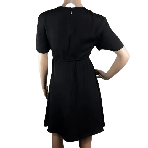 Black dress worn by a person on a plain background