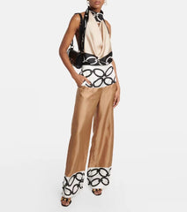 Woman wearing a stylish outfit with a top and pants featuring black and white pattern on a white background