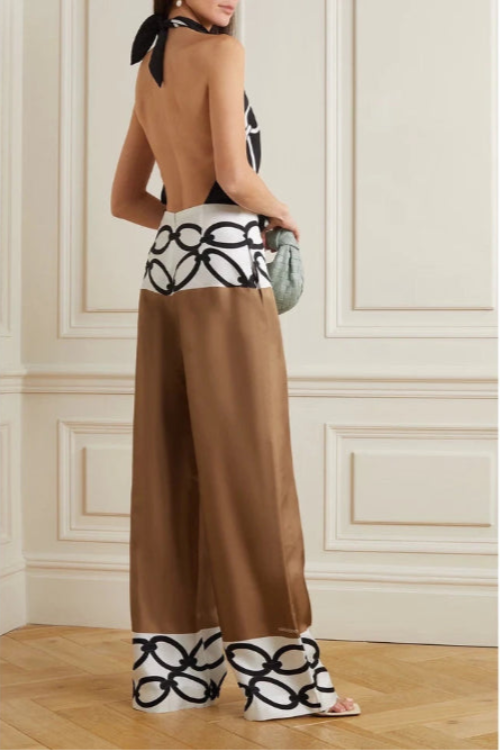 Woman wearing a brown dress with black and white patterned details in an elegant room.