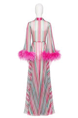 A long-sleeved maxi dress with vertical pink, green, and white stripes, featuring bright pink feather trim on the sleeves and collar, displayed on a white mannequin against a white background.