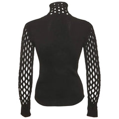 A black knit mock neck sweater with long, open-knit sleeves, shown from the back on a light gray background.