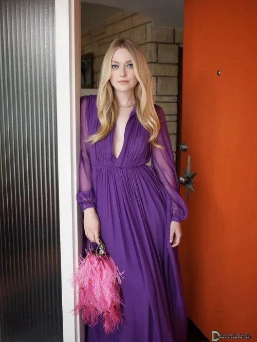 Woman in a purple dress holding a pink feathered clutch standing in a doorway.