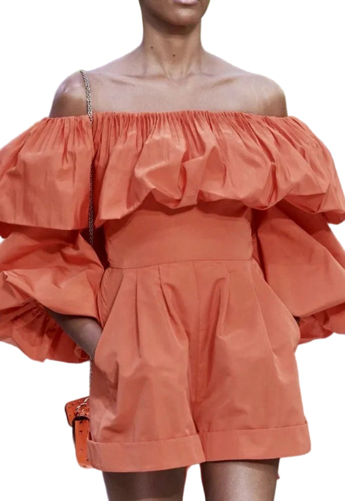 Coral off-shoulder dress with ruffled details on a white background