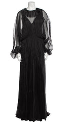 Black evening gown with sheer sleeves on a mannequin against a white background