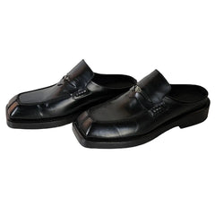 Pair of black loafers on a light wooden floor.