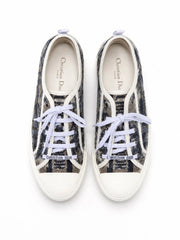 A pair of low-top canvas sneakers in black and white with white laces, photographed from a top-down angle on a white background.