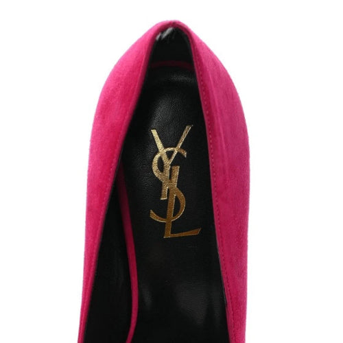 A close-up of a Yves Saint Laurent high heel shoe in vibrant magenta pink suede with a black leather insole featuring the gold metallic YSL logo.